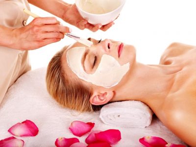 15232721 - woman with clay facial mask with rose petal. isolated.