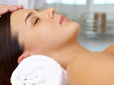 Portrait of young female enjoying the procedure of facial massage